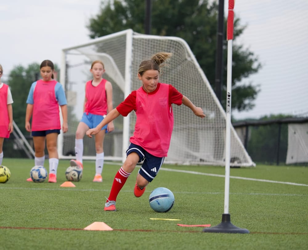 A young player dribbling through cones at SBV training